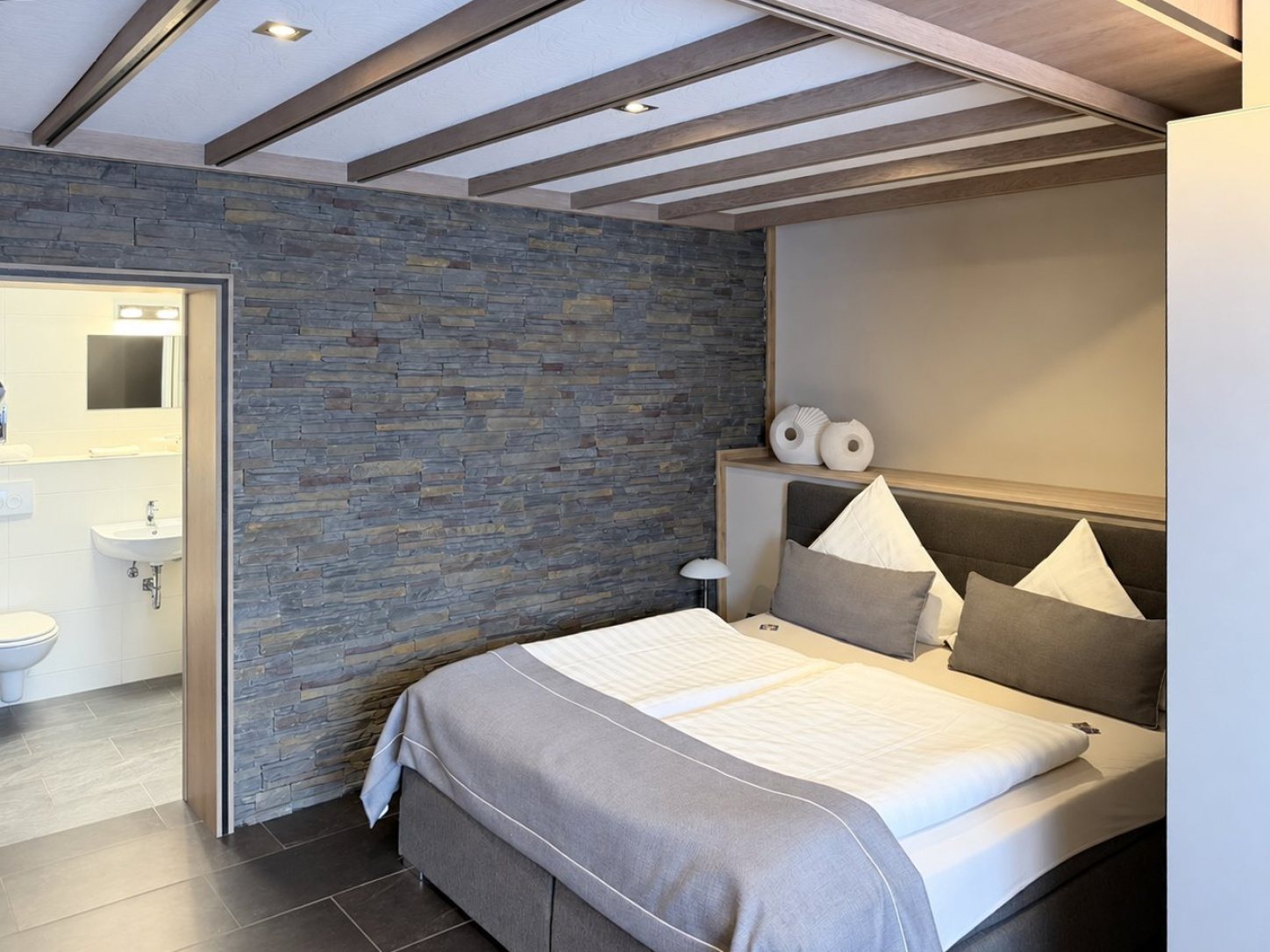 Doppelzimmer mit Natursteinwand und eigenem Bad