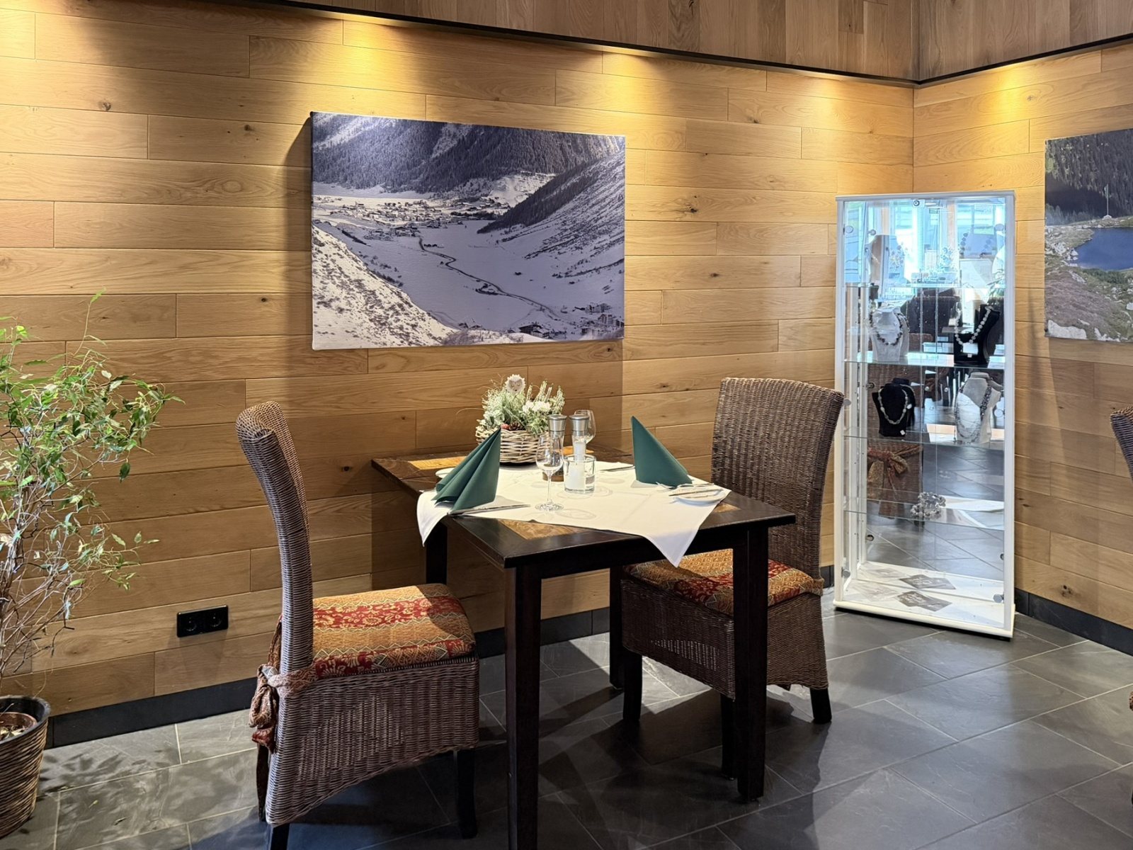 Gastraum im Restaurant Haus Schieferstein mit Holzw&auml;nden und gedeckten Tischen