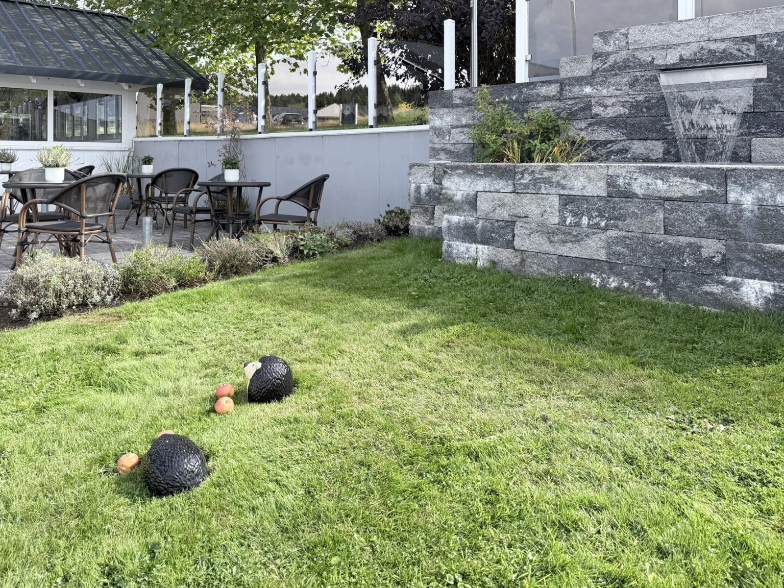 Rasen und Natursteinmauer am Garten